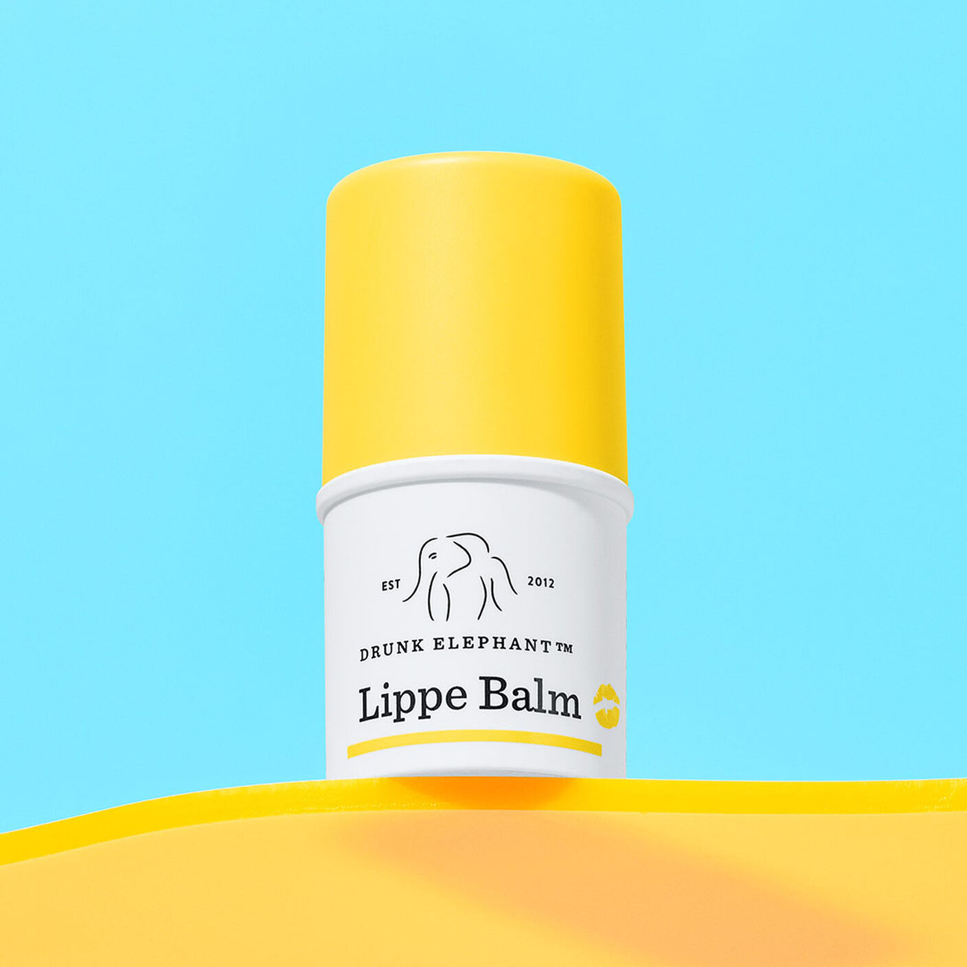 Lippe Balm on a yellow table on a blue background.