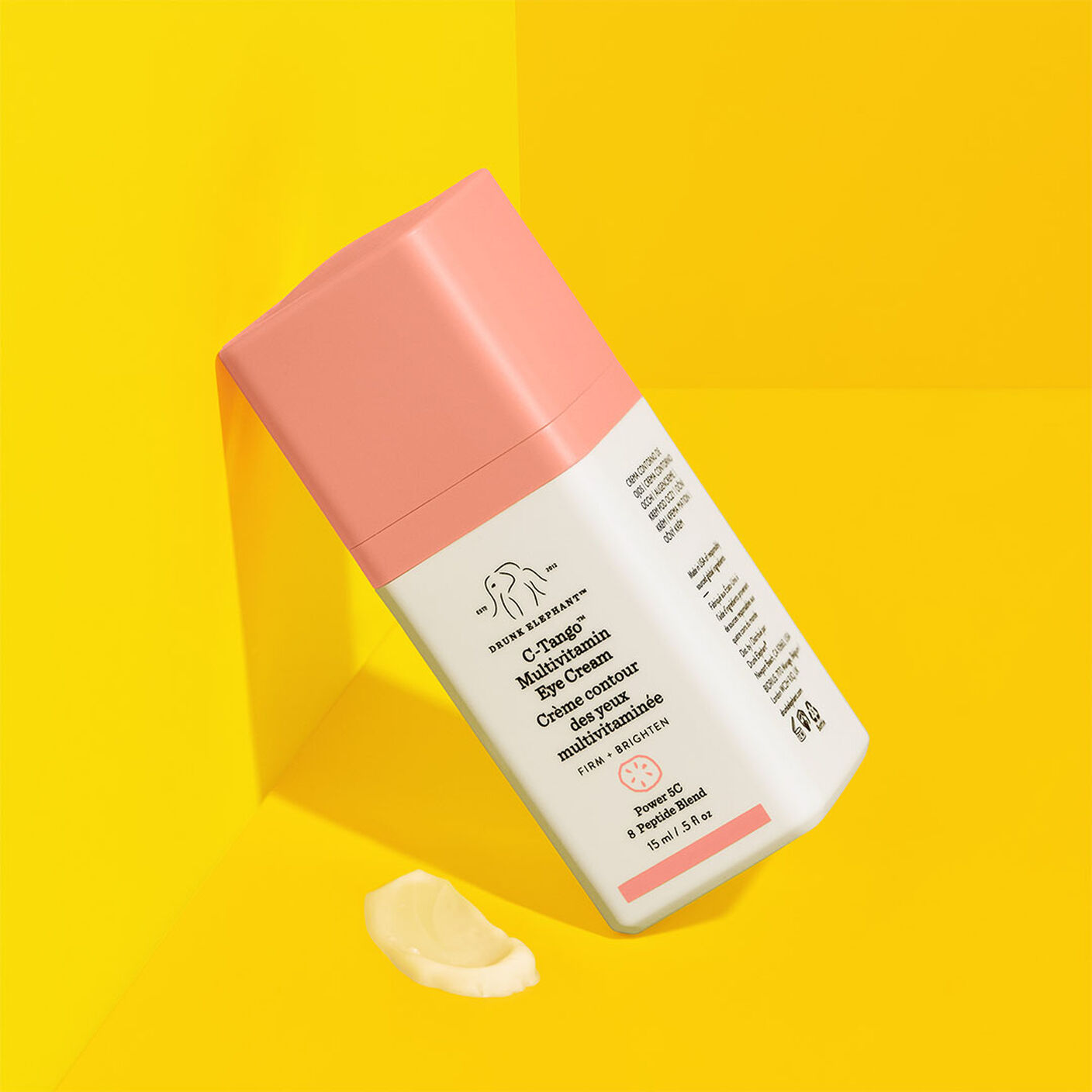 Crème contour des yeux multivitaminée C-Tango appuyée sur un fond jaune avec une petite trace de crème.