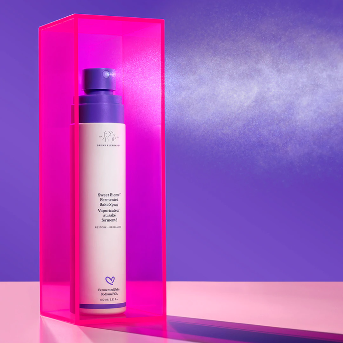 Sweet Biome™ Fermented Sake Spray against a purple background in a pink case
